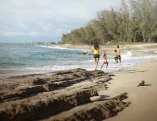 A family running on a beach